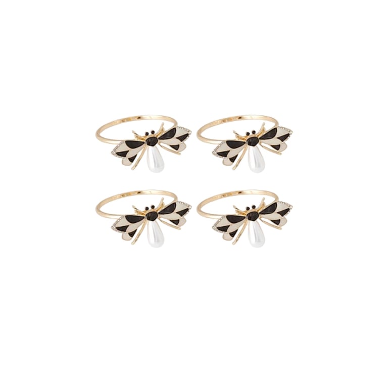 Set of four gold and black enamel bow-shaped napkin rings on white background