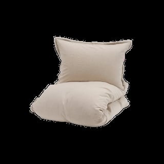 Beige pillow and rolled duvet or comforter set isolated on black background