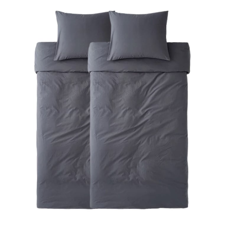 Top-down view of a gray bed with duvet cover, two pillows, and folded sheets on a white background