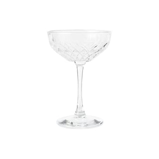 Empty crystal cocktail coupe glass with decorative cut pattern on white background