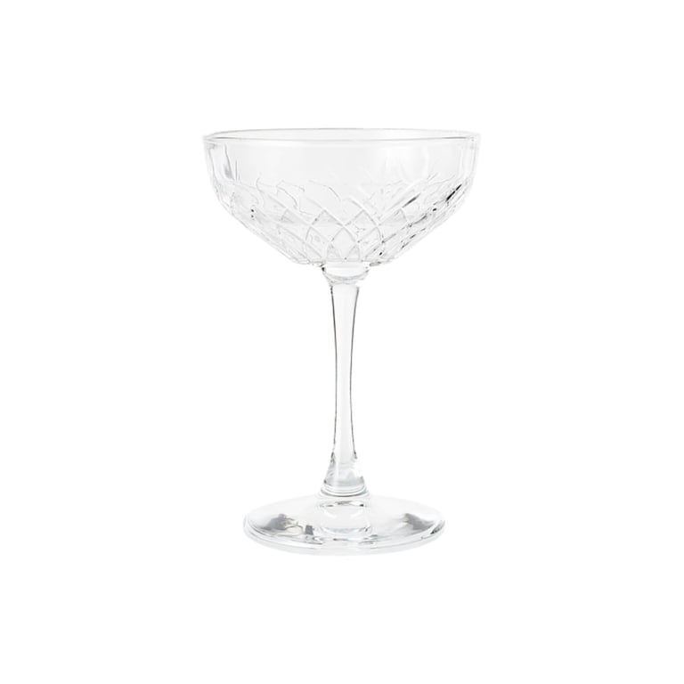 Empty crystal cocktail coupe glass with decorative cut pattern on white background