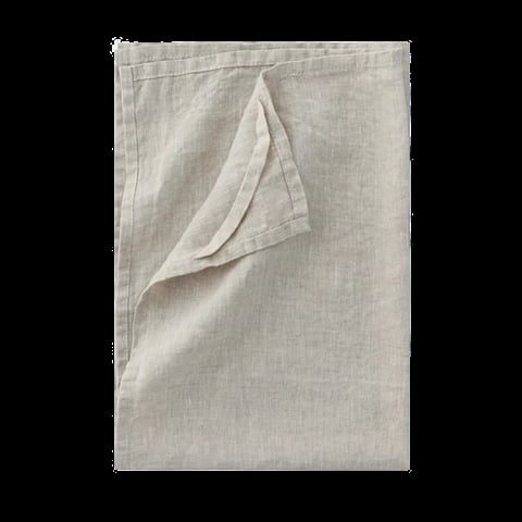 Folded corner of beige linen fabric, showing a peeled-back edge on a neutral woven textile background