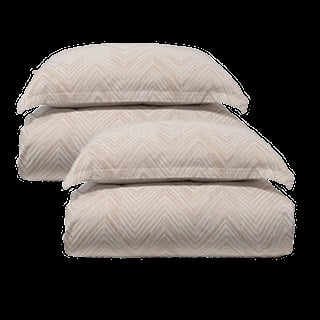 Stack of three folded quilts or comforters with chevron pattern in neutral beige and gray tones