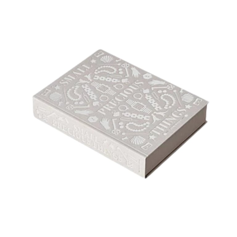 Silver decorative playing card deck box with ornate embossed patterns on lid, shown at an angle