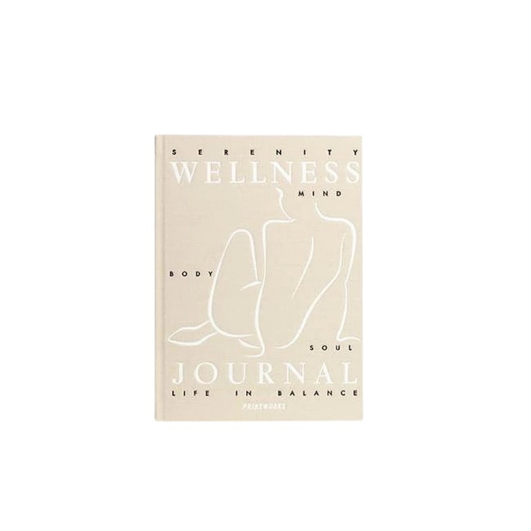 Wellness journal book with beige cover featuring minimalist line drawings and text about mind, body, and soul balance